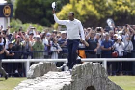 USA's Tiger Woods waves to the crowd as he goes over the Swilcan Bridge on the 18th. Picture: PA