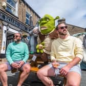 Jamie Talbot, and Ian Locke-Edmunds, of Leeds, enjoying a drink outside The Board Inn, Hawes with the Shrek creations made by the Hawes Yarnbombers. Picture: James Hardisty