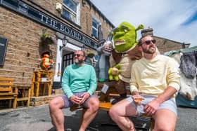 Jamie Talbot, and Ian Locke-Edmunds, of Leeds, enjoying a drink outside The Board Inn, Hawes with the Shrek creations made by the Hawes Yarnbombers. Picture: James Hardisty