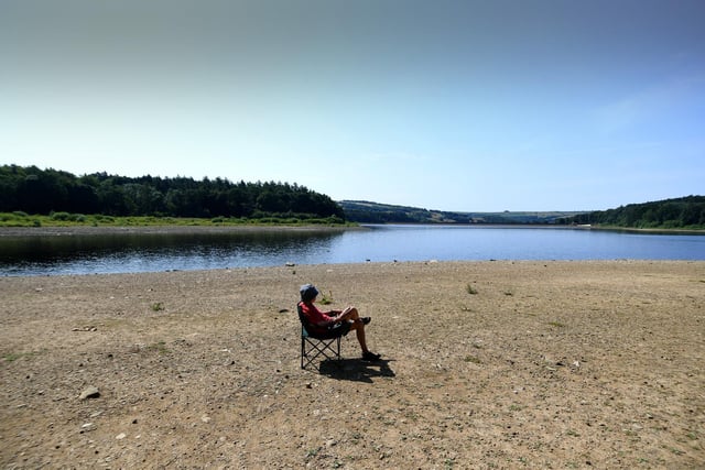 A man sunbathes on the new 'beach' at Swinsty Reservoir