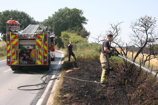 A firefighter sprays a jet of water onto a roadside fire in South Yorkshire  [Image: South Yorkshire Fire and Rescue]