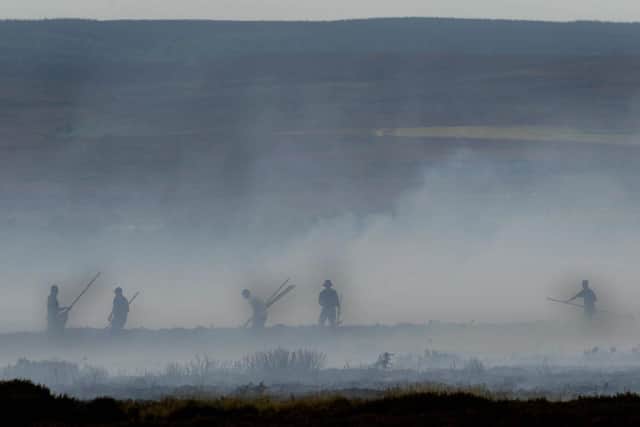 Firefighters and park workers damping down the flames on Fylingdales Moor, North Yorkshire, on September 18, 2003. Photo: Gareth Copley/PA.