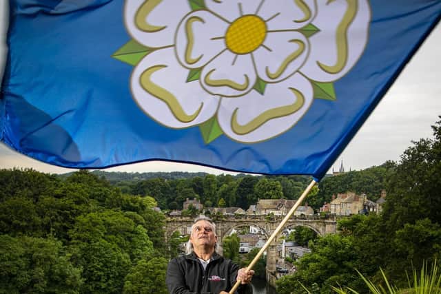 Andy Ormrod owner of Flying Colours waves one of his Yorkshire flags over Knaresborough