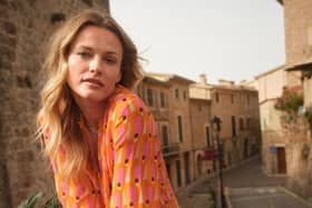 Fashion chain Next has raised its annual profit outlook after seeing full-price sales lift 5% in the past three months as the spell of hot weather boosted summer clothing purchases.
