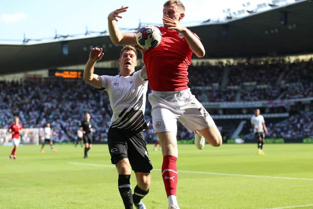 Derby County's James Collins (left) and Barnsley's Robbie Cundy battle for the ball (Picture: Nigel French/PA)