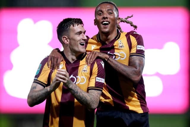Andy Cook of Bradford City celebrates with teammate Romoney Crichlow after victory in the Carabao Cup first round match between Bradford City and Hull City. Picture: George Wood/Getty Images.