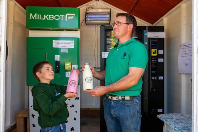 James and eight-year-old Harrison with one of their milk vending machines