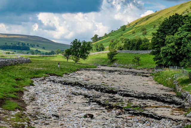 A walker by the River Skirfare in Littondale, dried up with the lack of rainfall this summer. The river ends where it joins the larger River Wharfe. The source is the confluence of Foxup Beck and Cosh Beck at the hamlet of Foxup. The river meanders consistently for almost 10 miles. Picture: Tony Johnson