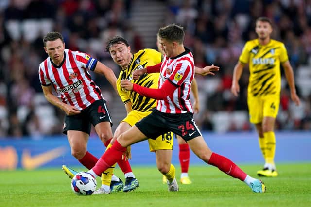 Rotherham United's Ollie Rathbone (centre) battles for the ball with Sunderland's Corry Evans (left) and Dan Neil (Picture: Owen Humphreys/PA)