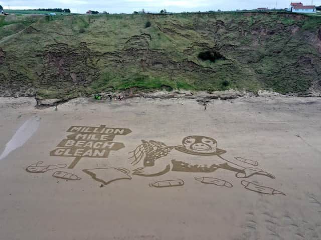 An aerial view of the 50-metre sand drawing created by Sand In Your Eye for Surfers Against Sewage's new Million Mile Beach Clean campaign, on Cayton Bay