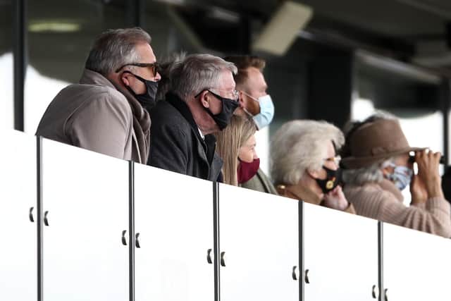 Sir Alex Ferguson (second left) watches his horses in action on day one of the Randox Grand National meeting. Owners, but not racegoers, were permitted to attend.