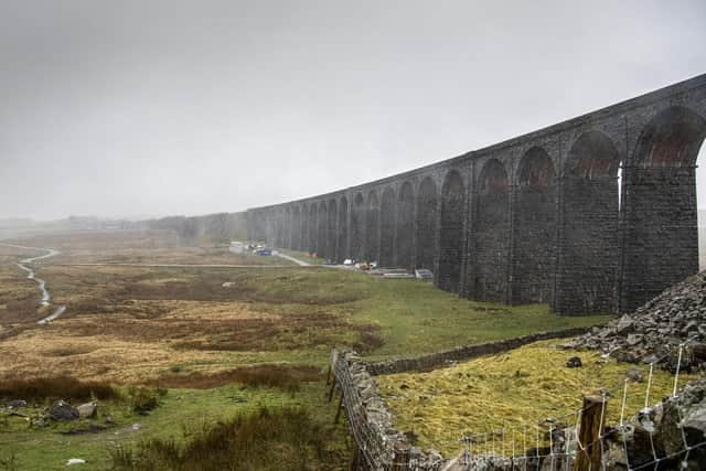 Railway workers disassemble scaffolding at Ribblehead Viaduct