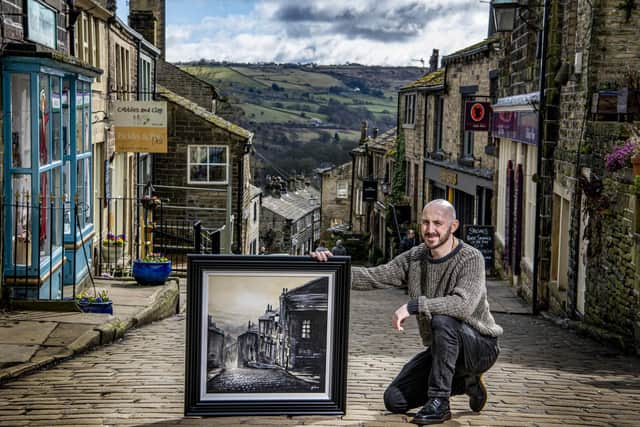Danny Abrahams on Main Street in Haworth with a painting of the scene. (Tony Johnson).