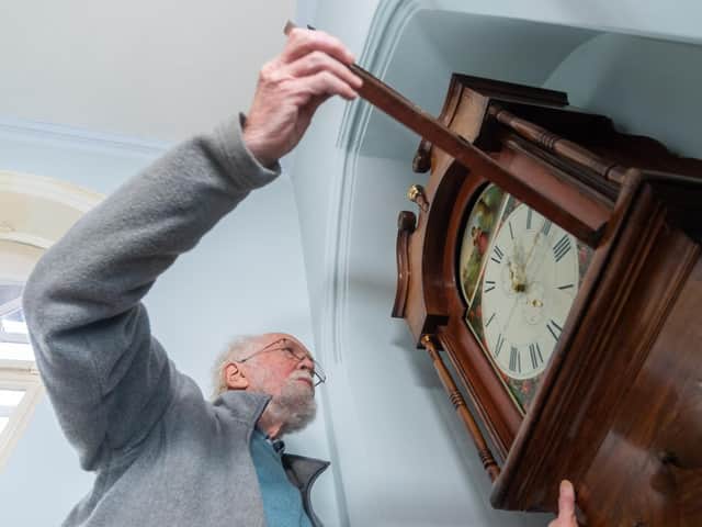 David Barker, a Fellow of the British Horological Institute (FBHI) and Accredited Conservator Restorer (ACR) checking the time on the grandfather clock