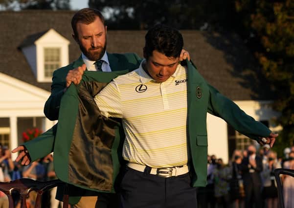 Perfect fit|: Hideki Matsuyama puts on the champion's green jacket with help from Dustin Johnson after winning the Masters. Picture: AP Photo/David J Phillip