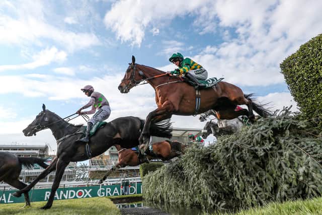 Minella Times and Rachael Blackmore (green and gold colours) clear the water jump in the Randox Grand National.