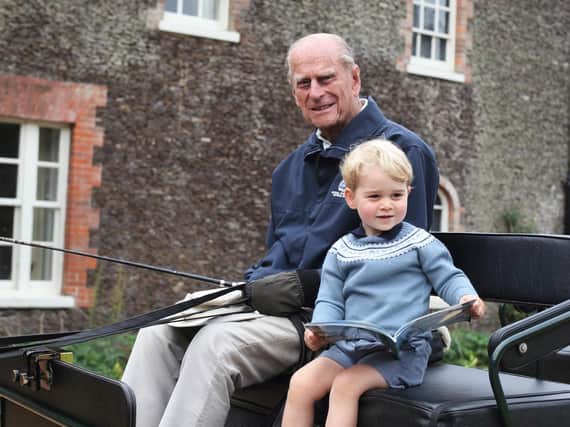The Duke of Cambridge released a new photograph, taken by his wife, of a then two-year-old Prince George with his great-grandfather in one of his beloved carriages on the Sandringham Estate in Norfolk.