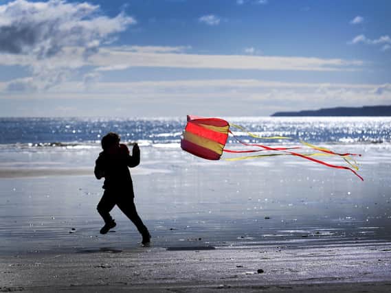 A child plays with a kite at the beach in Scarborough