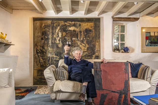 Ronnie with work by Alan Davie titled Blood Creation from 1952 hanging on the wall in his front room and Image of Reds by Trevor Bell painted in 1958. Picture: Tony Johnson.