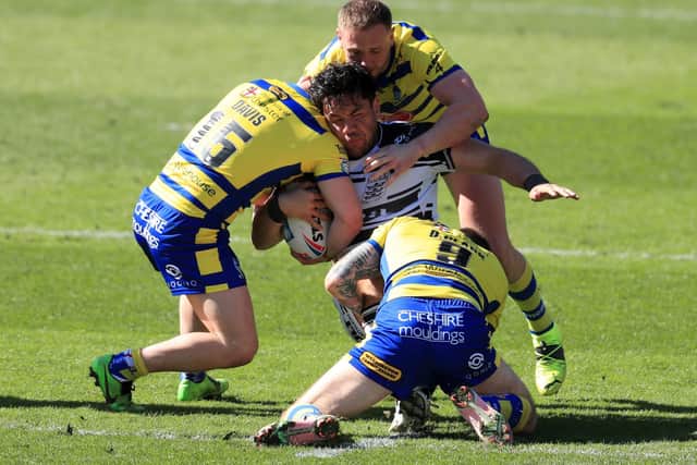 Hull FC's Andre Savelio is tackled by Warrington Wolves' Matt Davis, Daryl Clark and Ben Currie.