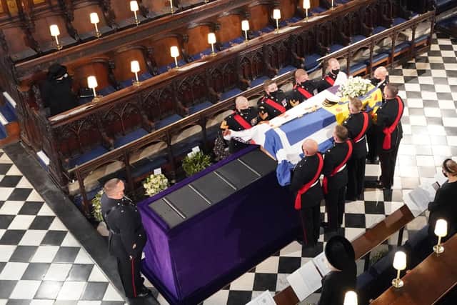 The Queen watches on as Prince Philip's coffin is carried into St George's Chapel for his funeral.
