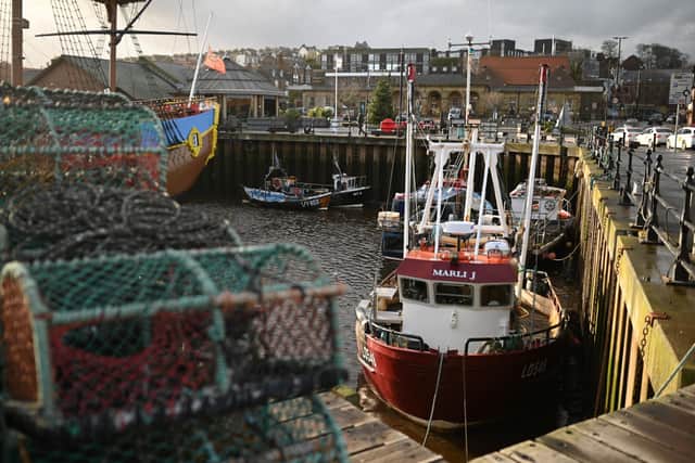 Ropes and empty lobster pots sits on the quayside as fishing boats are moored in the harbour at Whitby.