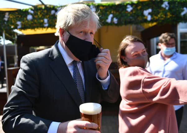 Prime Minister Boris Johnson removes his mask to enjoy a pint in the beer garden during a visit to The Mount Taven public house and restaurant in Wolverhampton, West Midlands, on the local election campaign trail. Picture: Jacob King/PA Wire