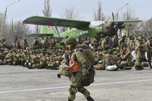 A Russian paratrooper walks as other wait to be load into a plane for airborne drills during maneuvers in Taganrog, Russia, Thursday, April 22, 2021. Russia's defense minister on Thursday ordered troops back to their permanent bases following massive drills amid tensions with Ukraine, but said that they should leave their weapons behind in western Russia for another exercise later this year. (AP Photo)