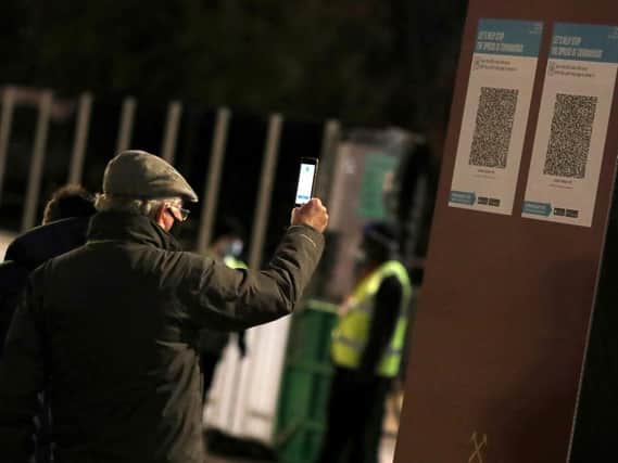 A West Ham United fans scans a track and trace code in December 2020. Picture: PA
