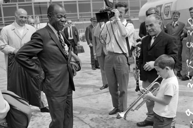 Seven year-old Enrico Tomasso serenades Louis Armstrong as he arrives in Yorkshire for a residency at Batley Variety Club. (YPN).