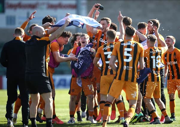 Champagne moment: Hull City players celebrate promotion to the Championship after the final whistle against Lincoln. Picture: Tim Goode/PA Wire.