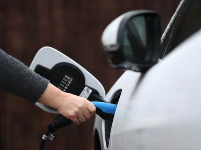 An electric charging cable connected to a Jaguar I-Pace electric car at a residential home. Byline: Andrew Matthews/PA.