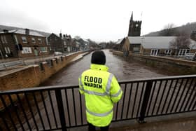 A flood warden looks at the water levels of the River Calder in Mytholmroyd in the Upper Calder Valley in West Yorkshire. Photo: PA