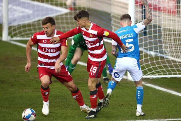 Peterborough United's Sammie Szmodics (right) and Doncaster Rovers' Branden Horton (centre) and Andy Butler all battle for the ball. Picture: PA