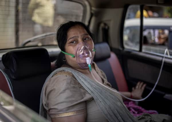 A COVID-19 patient sits inside a car and breathes with the help of oxygen provided by a Gurdwara, a Sikh house of worship, in New Delhi, India.