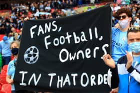 Fans hold up a banner protesting against the European Super League ahead of the Carabao Cup Final at Wembley Stadium, London.