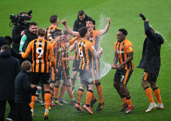 Let us spray: Hull City  forward Mallik Wilks, above right, sprays his team-mates with champagne after helping the Tigers to the League 1 title. Picture: Jonathan Gawthorpe