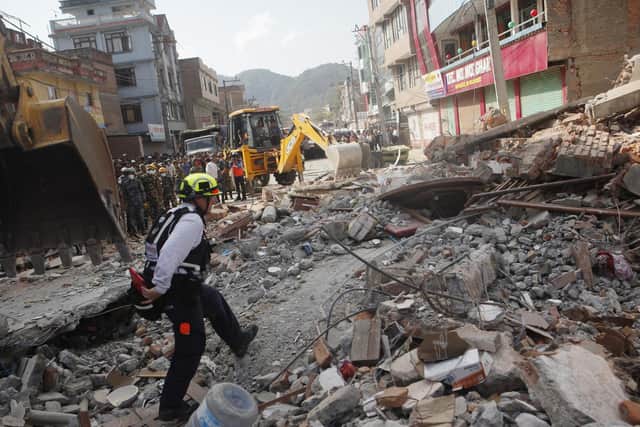A rescue worker from USAID inspects the site of a building that collapsed in an earthquake in Kathmandu, Nepal in 2015. Jim Morton is raising money for the Gurkha Welfare Trust to help build houses for those who were destroyed. Photo credit: AP Photo/Niranjan Shrestha