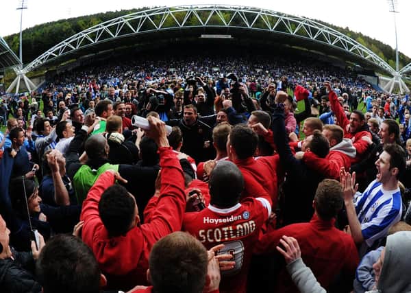 Love-in: Huddersfield and Barnsley fans celebrate survival together. Picture: Mark Bickerdike.