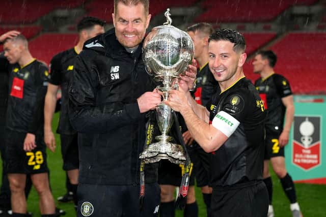 It's ours: Harrogate Town manager Simon Weaver, left, and Josh Falkingham celebrate with the Buildbase FA Trophy. Picture: PA