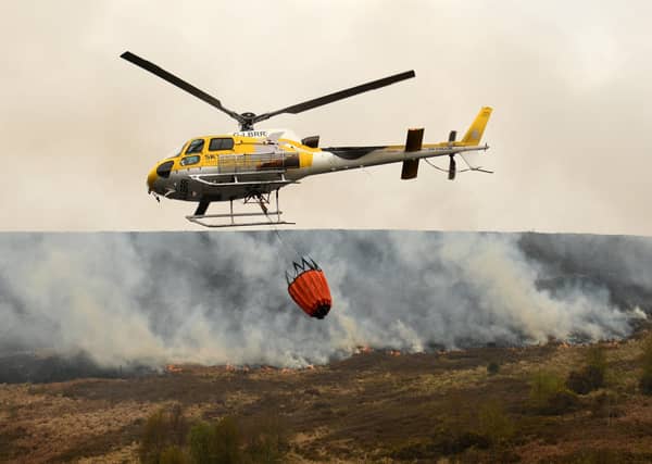 A helicopter drops water, taken from a nearby reservoir, onto the flames after a resurgence of the moor fire on Marsden Moor, near Huddersfield last week.