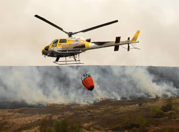A helicopter drops water, taken from a nearby reservoir, onto the flames after a resurgence of the moor fire on Marsden Moor, near Huddersfield last week.