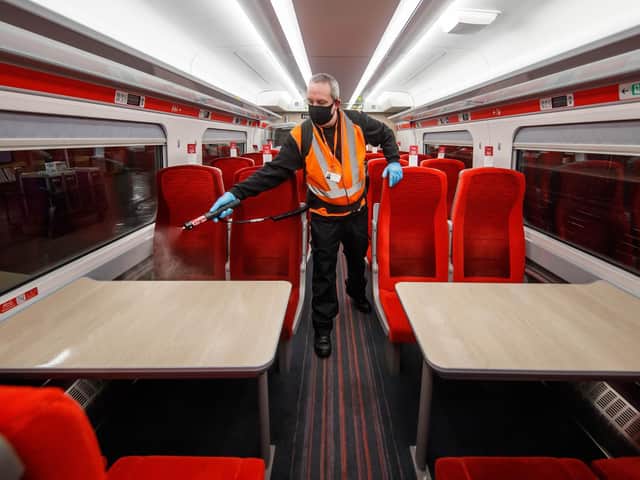 Library image of a cleaner using a fogging machine to clean a train carriage during the night