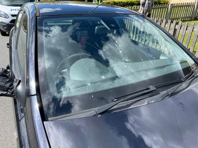 One of the cars with a smashed windscreen