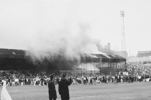 Crowds on the pitch at Bradford City's Valley Parade stadium after the stand caught fire. In less than five minutes the whole Main Stand was ablaze causing the deaths of 56 supporters in one of the worst incidents in British football, 11th May 1985. Photo credit: Keystone/Hulton Archive/Getty Images