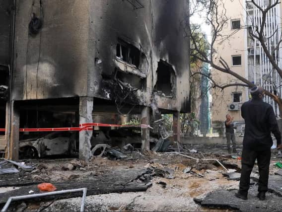 Israeli men check the damages after a rocket attack from the Hamas-controlled Gaza Strip, in the central Israeli city of Petah Tikva