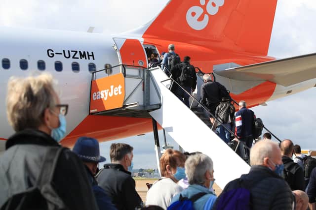 Passengers prepare to board an easyJet flight to Faro, Portugal, as the lockdown is eased.