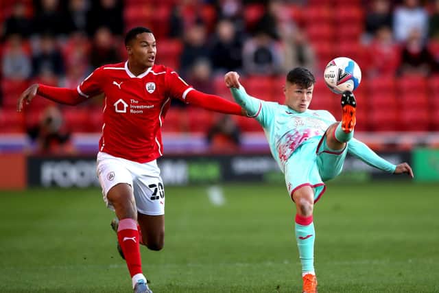 BIG NIGHT: Barnsley's Toby Sibbick (left) and Swansea City's Liam Cullen battle for the ball at Oakwell Stadium. Picture: Nick Potts/PA