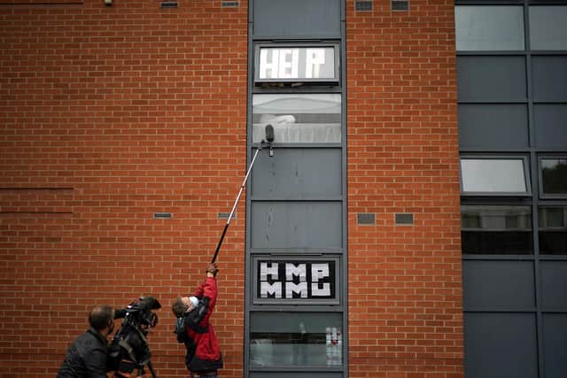 Pictured isolating students peer out of their accommodation window as they are interviewed by a television crew last year  in Manchester. The previous two academic years have been disrupted - with many students having to spend time isolating and months off campus. Photo credit: Christopher Furlong/Getty Images.