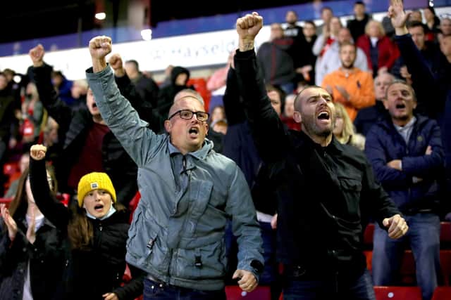 Come on you Reds: Barnsley fans cheer from the stands during the game against Swansea City.